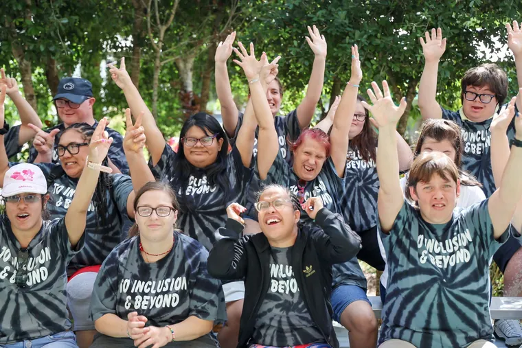 Ascend members posing together in matching tie-dye shirts at a community event