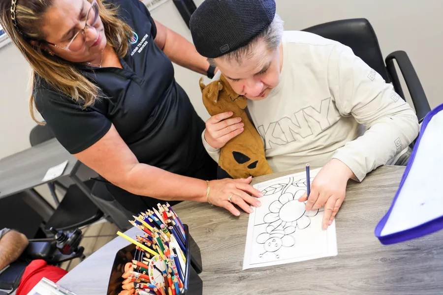 An Ascend staff member supporting a participant during a respite care session