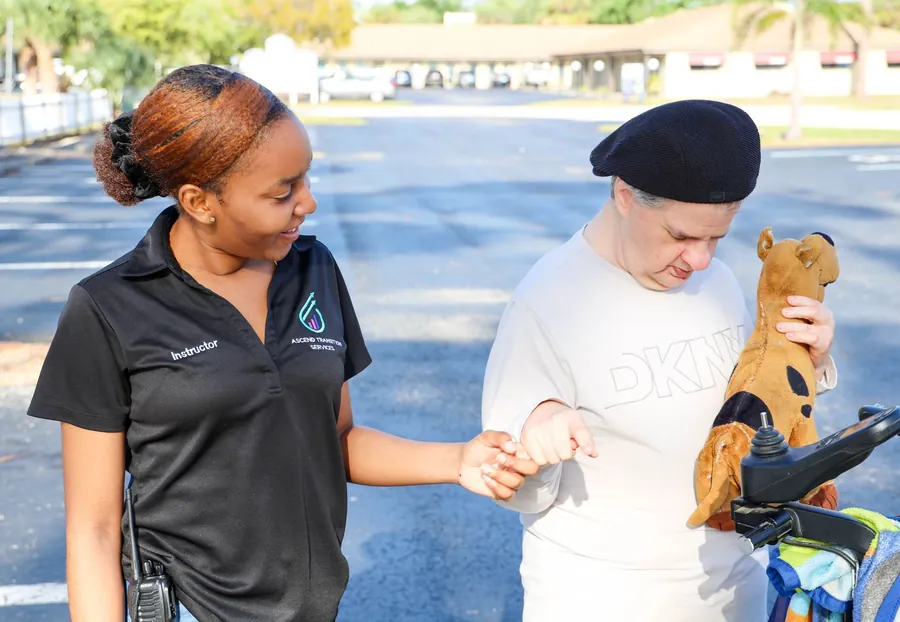 Ascend staff member helping a participant with an art and life skills activity at a table